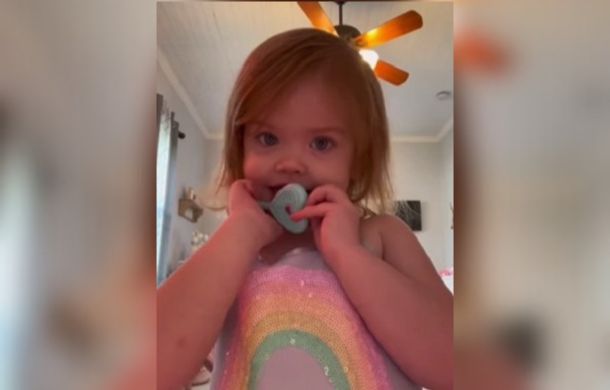 Image shows a toddler looking into a camera right before she has a moment of self-awareness and understands that she is looking at herself.