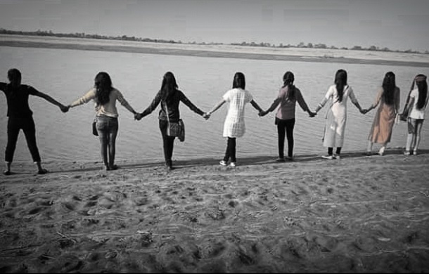 Image displays a group of people holding hands to signify the Texas state motto of friendship.
