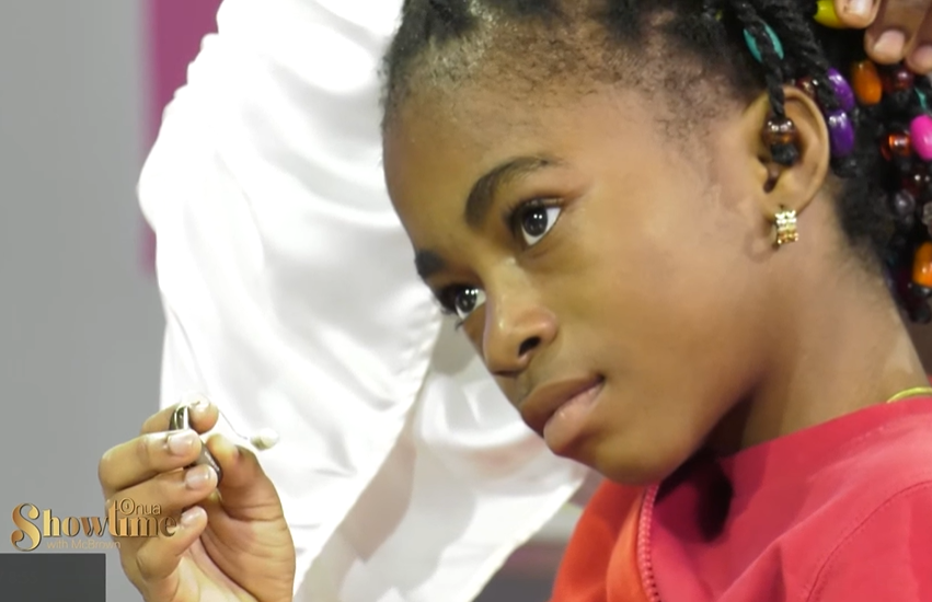 Close up of Abigail Adjiri as she holds one of her hearing aid's in her hand on "Onua Showtime with Nana Ama McBrown."