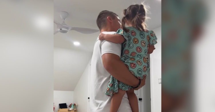 dad holding daughter in arms