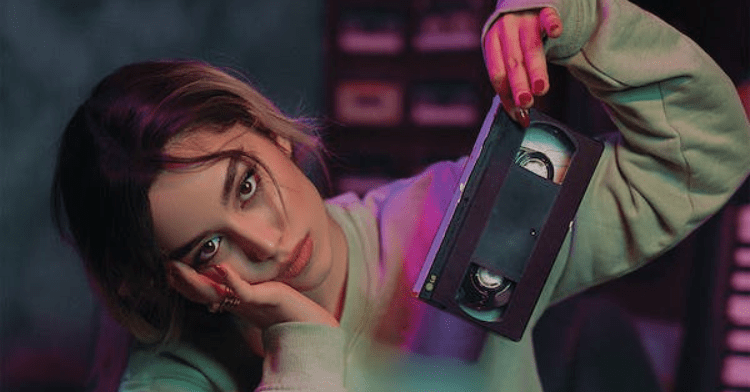 Girl holding vhs tape.