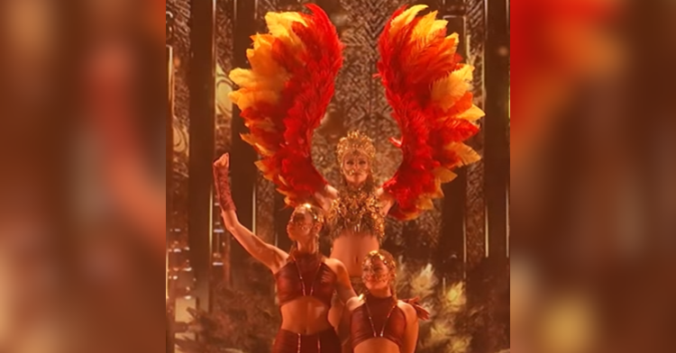woman dressed as phoenix stands with two women