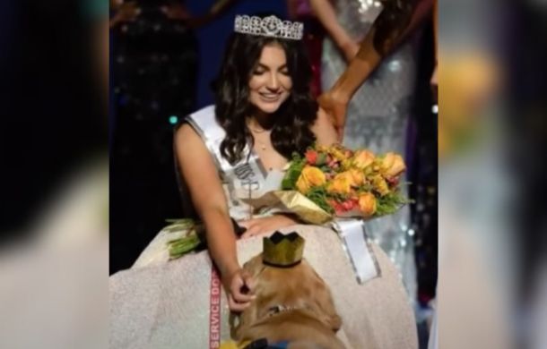 Alison Appleby petting her epilepsy service dog Brady after pageant winner donned his own little crown.