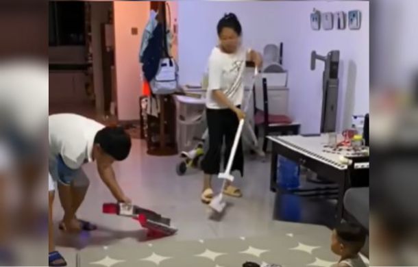 dad picks up rug while mom cleans
