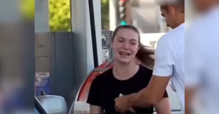 Image shows a man handing a woman gas money after filling her fuel tank.