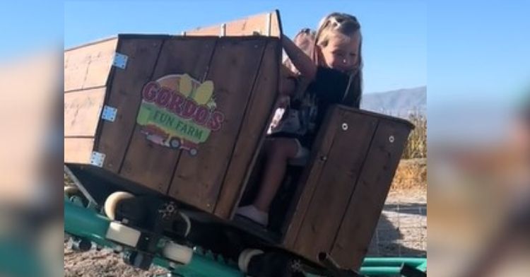 Image shows two girls in a small roller coaster car.