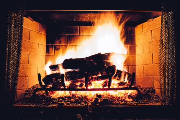 Image shows a roaring fire in a fireplace.