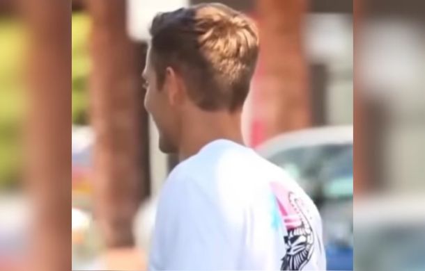 Image shows a man from the left side talking to a woman after handing her gas money.