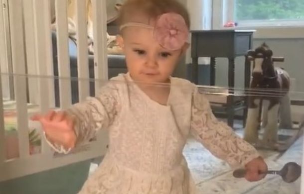 Toddler reaches out to touch a cling wrap barrier during the Invisible Challenge.