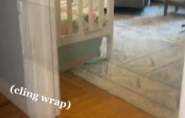Image shows a doorway set up for "The Invisible Challenge" with cling wrap stretched across the threshold.