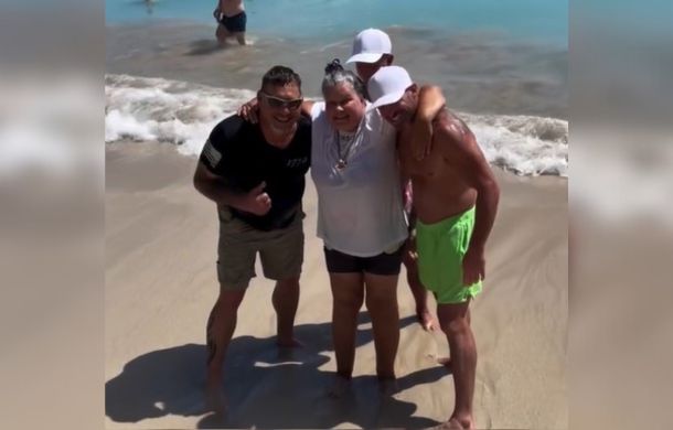 woman poses with the men who helped her go into the ocean for the first time