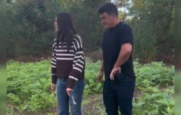 Image shows a couple in the woods. The man is reaching in his left front pocket while the woman stares off to the side. What you don't see is the man's perfect wingman, his pet dog, distracting the woman while he pulls a special item from his pocket.