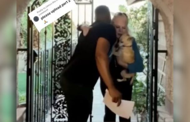 After meeting the stranger who found her lost pup, she gave him a hug. Image shows the dog owner, the stranger, and the lost pup sharing a hug.