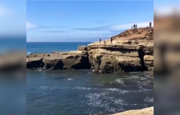 Image shows people standing near a cliff, a kid's intrusive thoughts creates a teachable moment for the Mom taking the video.