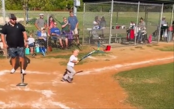 A Tee Ball hitter leaves the batter's box after a hit.