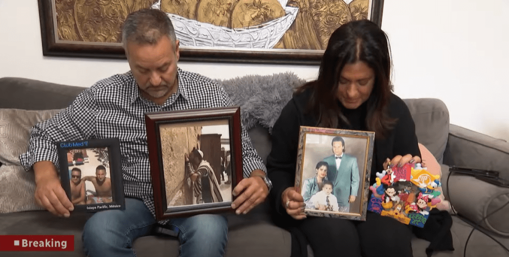 Alain and Raquel Look somberly look down at the framed photographs in their hands, all of which feature their late son, Alexandre Look.