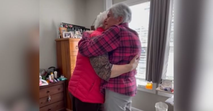 Two best friends in their eighties hug during a surprise visit.