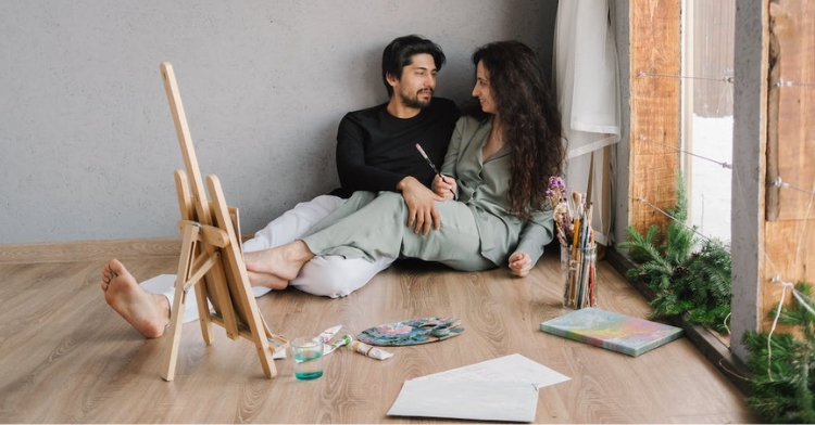 couple painting sitting on floor