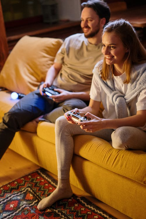 A couple sitting on the couch, gaming