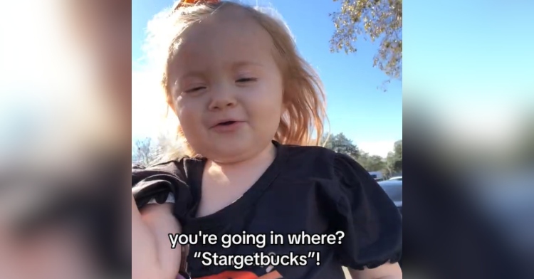 View of a little girl being held by her mom. Text on the image reads: "you're going in where" and "Stargetbucks!"