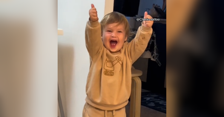 Toddler gives thumbs up.