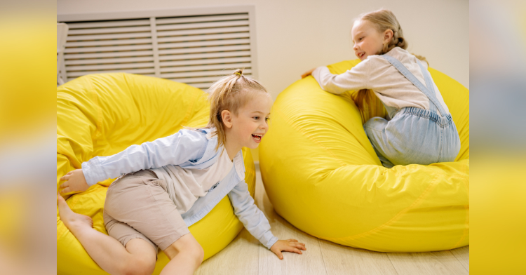 two girls playing on yellow cushions