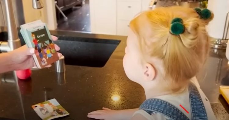 Image shows toddler genius Isla McNabb reading flash cards at two years old.