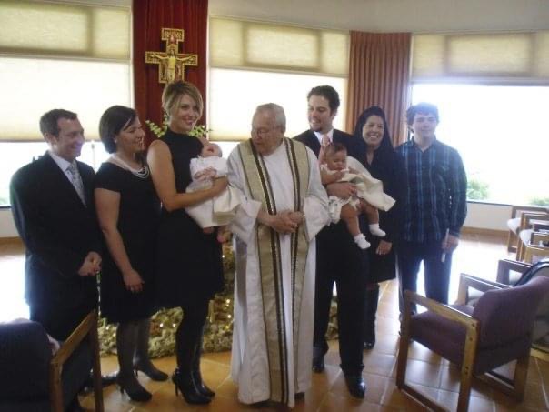 Kerstin Lindquis smiles as she holds a baby and poses for a photo with others at church, including a pastor.