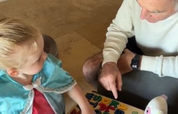 Michael Wood, inventor of LeapFrog learning systems, shows his granddaughter how to use the original Phonics Desk prototype.