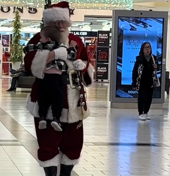 toddler hugs a mall Santa