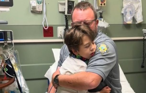 Shaken Baby Syndrome survivor Beckett getting a hug from his dad during a hospital visit for rhino virus.