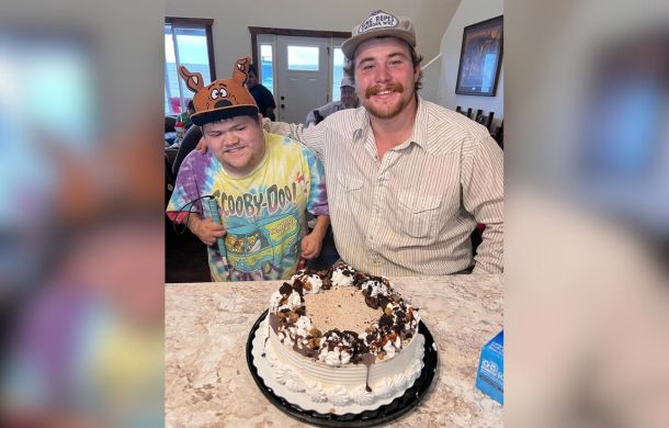 Cam (28) and Cody (23) share a birthday celebration with a cake.