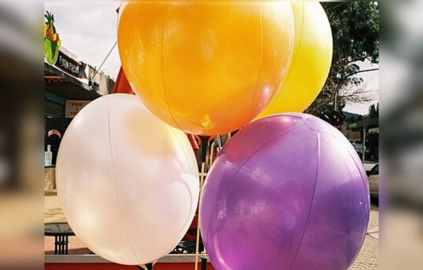 Image shows four balloon of different colors to promote the wacky fact that humans fart enough to fill a balloon every day!