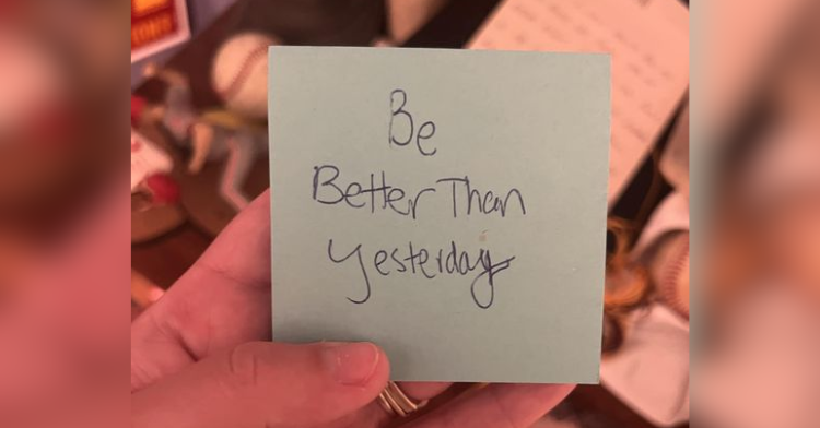 Sticky note with written note "Be better than yesterday."