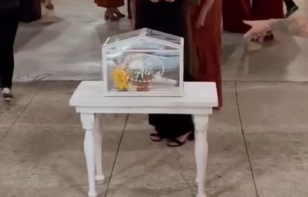 A unique bouquet toss with the bouquet locked inside a glass enclosed box.