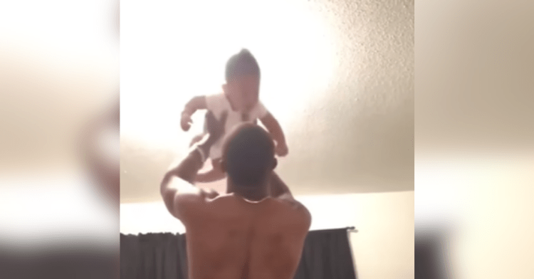 dad holds baby in air