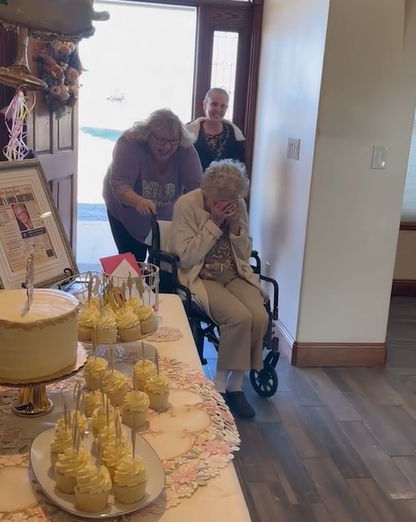 A 100-year-old grandma cries at her surprise birthday party. 