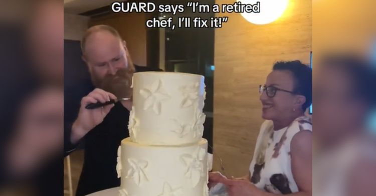 A security guard fixes a wedding cake with frosting.