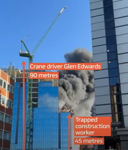 View from a distance of the building that crane operator Glen Edwards rescued a man from. Text on the image show the distance from Glen Driver and the ground, which was 90 meters. It also shows the distance of the trapped construction worker and the ground which was 45 meters. Smoke is billowing from the side of the building.