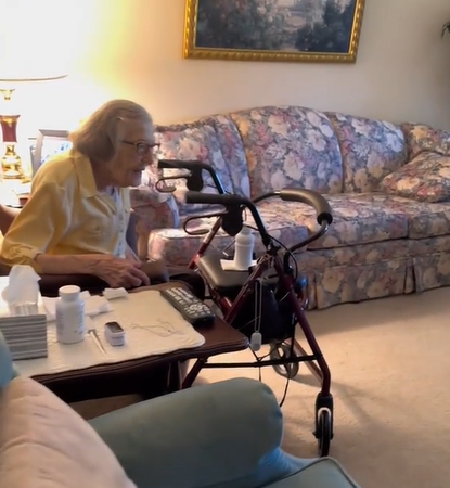 An elderly woman sits in her chair waiting for her surprise.