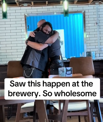 Two men at the bar sharing a sweet hug. 