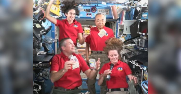 A group of astronauts share a Thanksgiving meal in space.