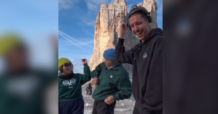 three folks dancing on a mountain