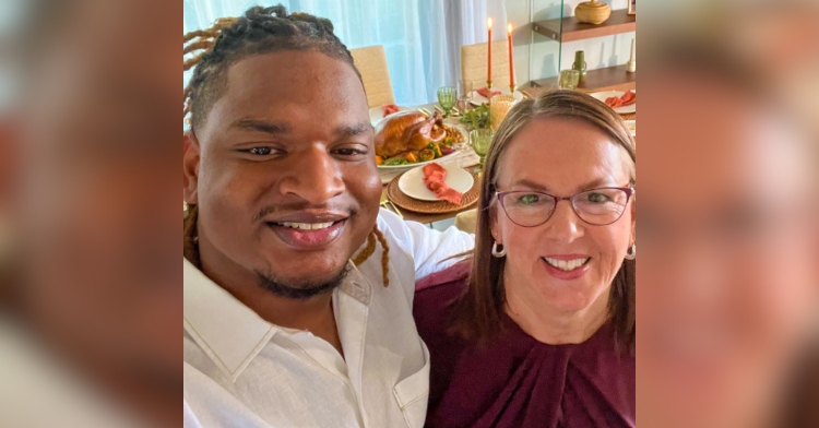 Selfie of a man named Jamal and a grandma named Wanda. They're both smiling. In the background we can see a dining room table adorned with Thanksgiving food.