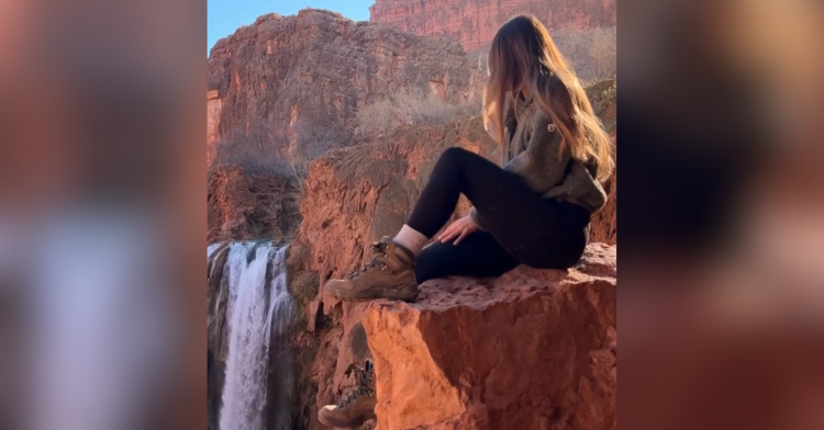 girl sitting by waterfall
