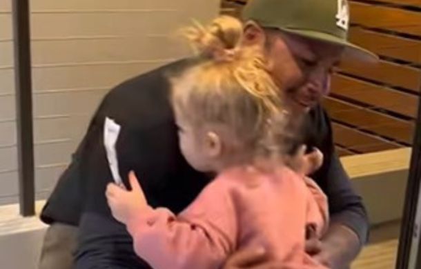 Ex-husband getting a hug from the child of his ex-spouse and her new husband.