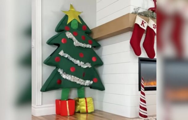 Hiding in plain sight. Dog mom is dressed as a Christmas tree to play husky hide and seek.
