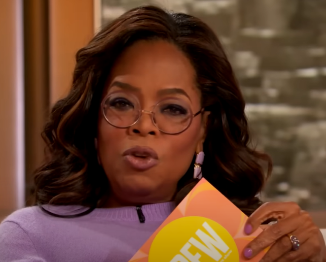 Oprah holding a card on the Drew Barrymore Show.