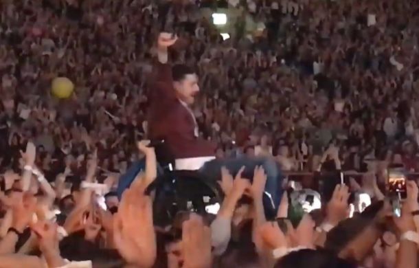 In a wheelchair at a Coldplay concert, this man was crowd-surfed to the stage to appear with Chris Martin.