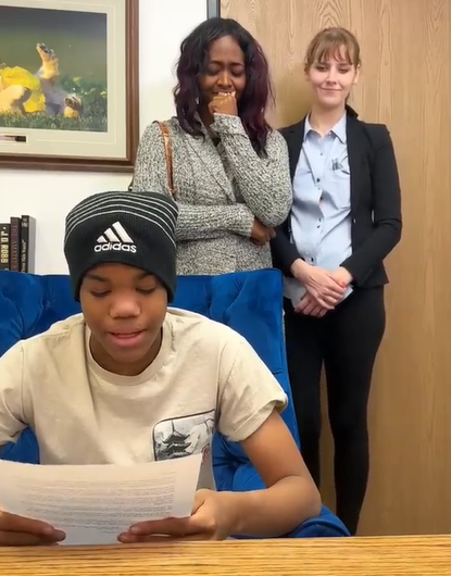 A boy reading a letter asking his aunt to adopt him.